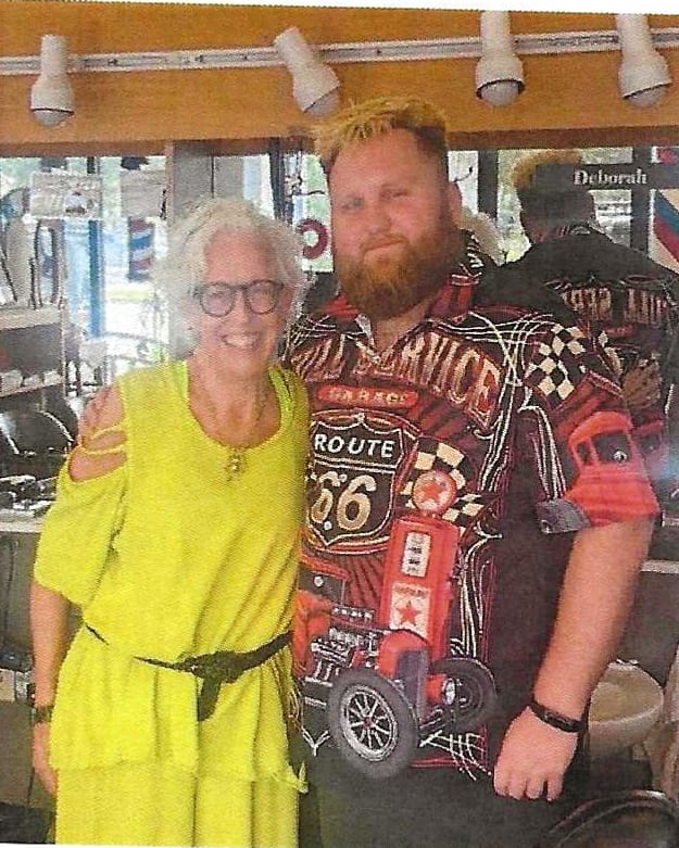 Deborah Kelch McIvaine and Kyle Wason standing together inside the barbershop